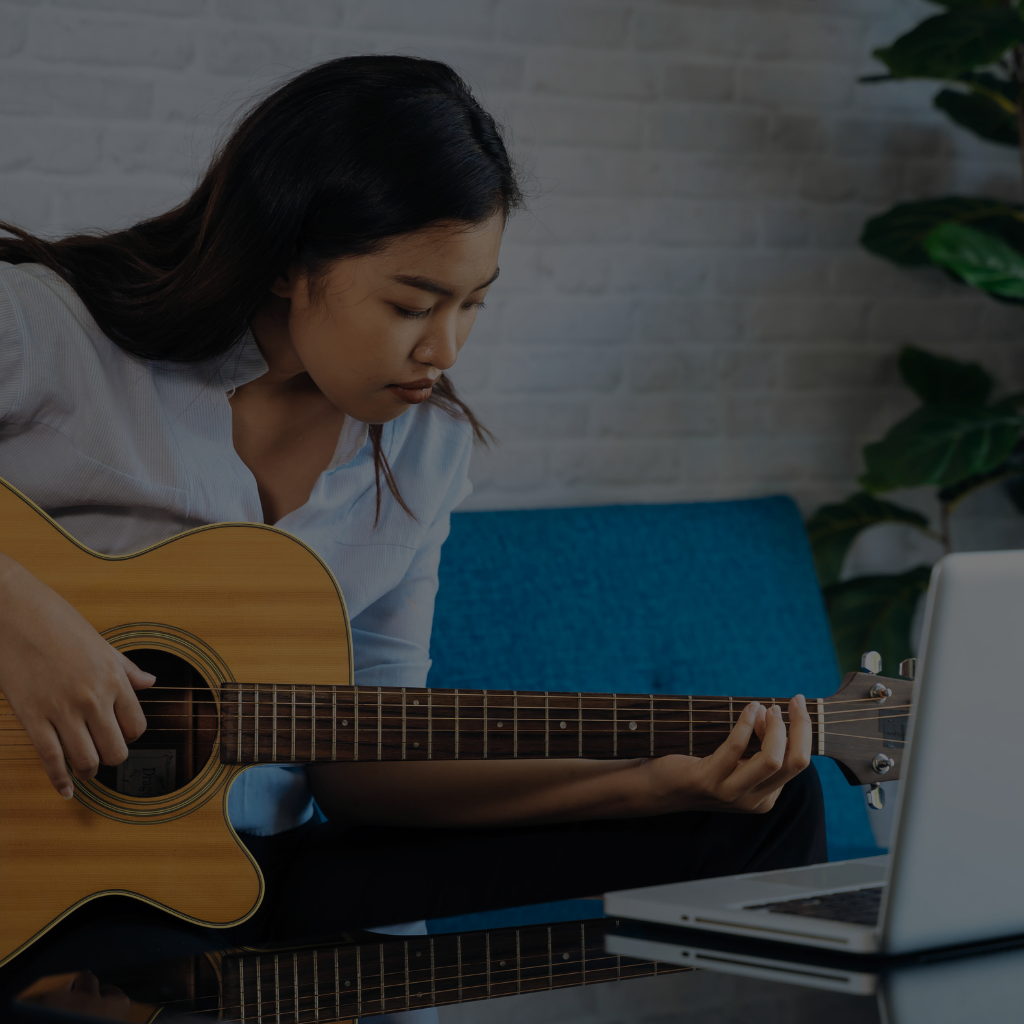 Woman learning guitar online